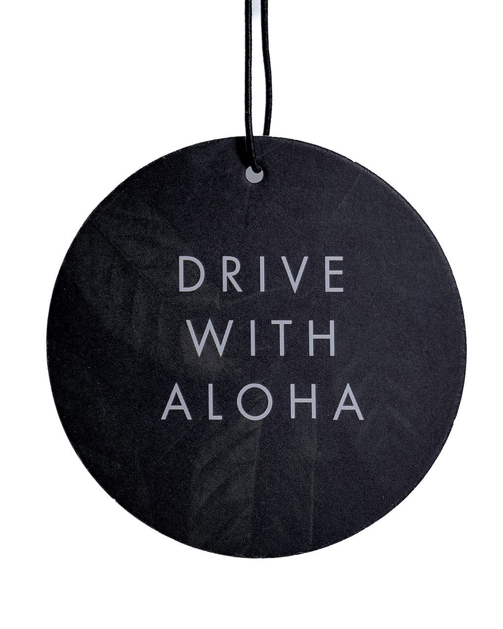 Round black air freshener with 'Drive With Aloha' text on a white background