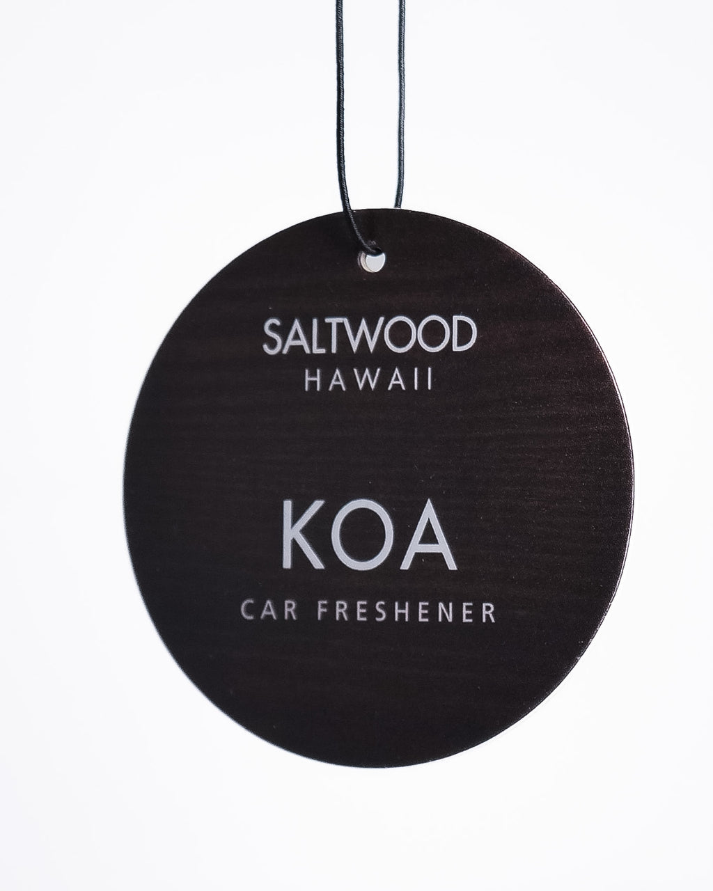 Round black car freshener with 'Saltwood Hawaii' and 'Koa' text on a white background