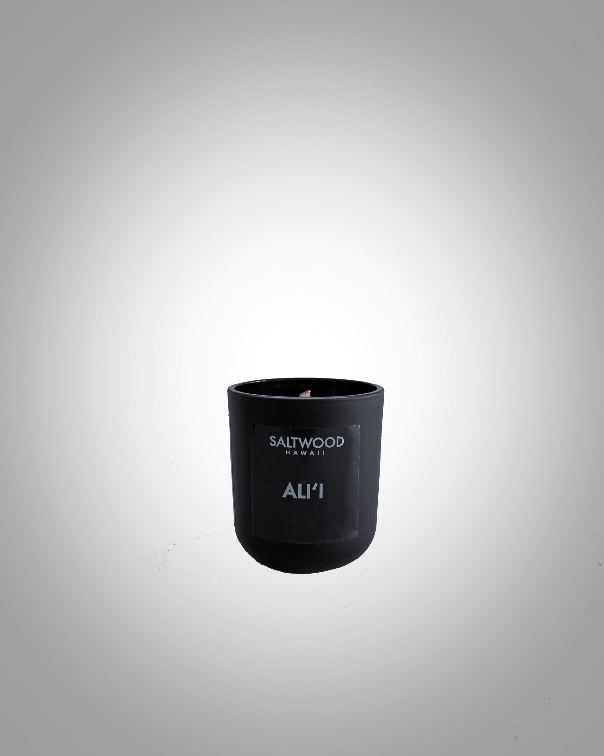 A black candle jar with the word 'ALI'I' written on it against a grey background.