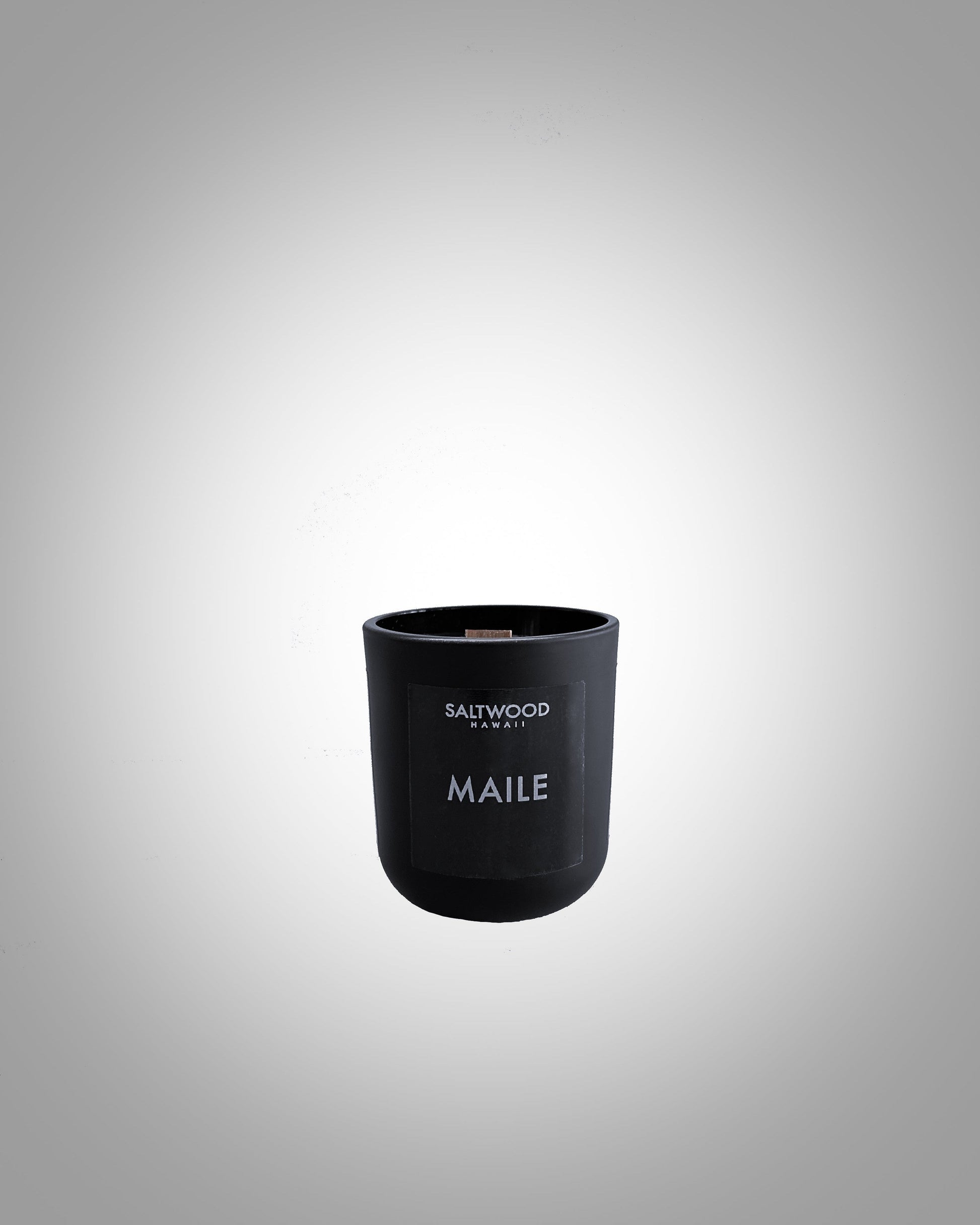 A black 3 oz candle with a label that reads 'MAILE' and 'SALTWOOD'.